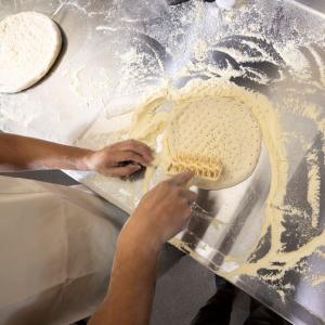 Hands rolling dough